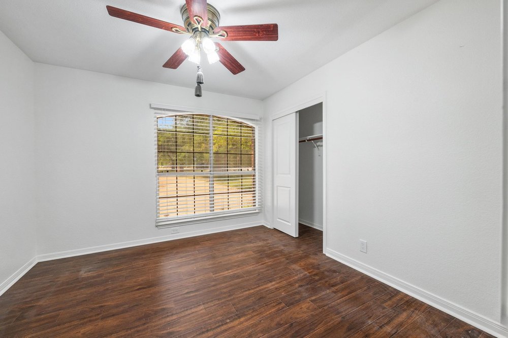 209 El Rio Drive Lakeway, TX 78734 - Photo 26 of 40 a view of an empty room with wooden floor and a window