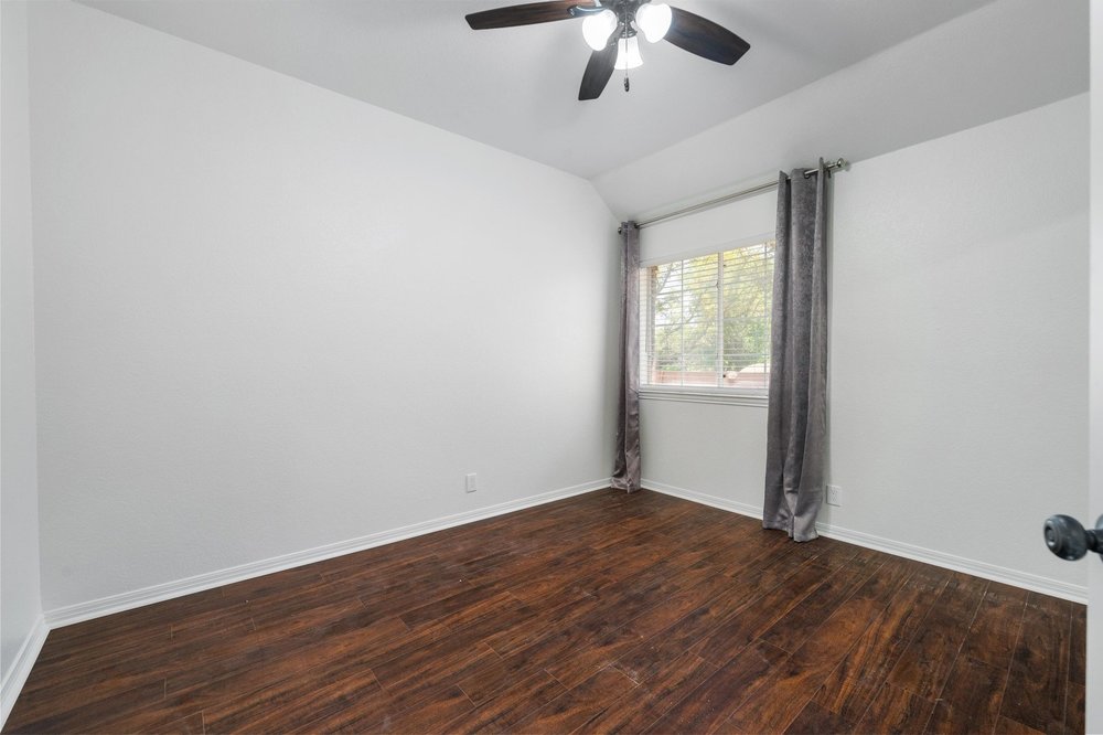 209 El Rio Drive Lakeway, TX 78734 - Photo 28 of 40 a view of an empty room with wooden floor and a window