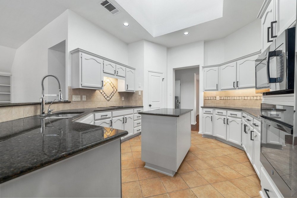 209 El Rio Drive Lakeway, TX 78734 - Photo 3 of 40 a kitchen with stainless steel appliances granite countertop a sink stove and cabinets