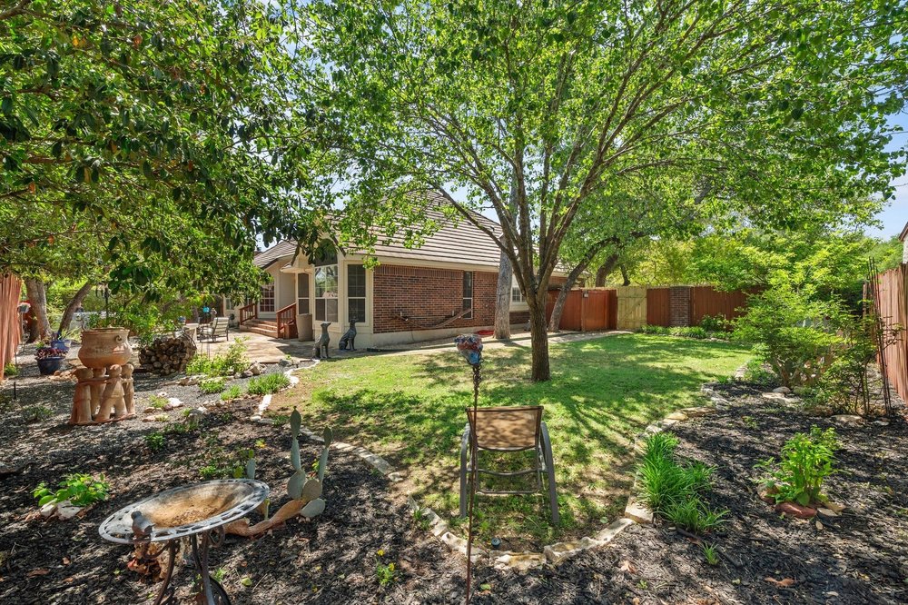 209 El Rio Drive Lakeway, TX 78734 - Photo 31 of 40 a backyard of a house with lots of green space
