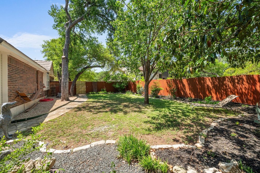 209 El Rio Drive Lakeway, TX 78734 - Photo 35 of 40 a view of a backyard with a tree