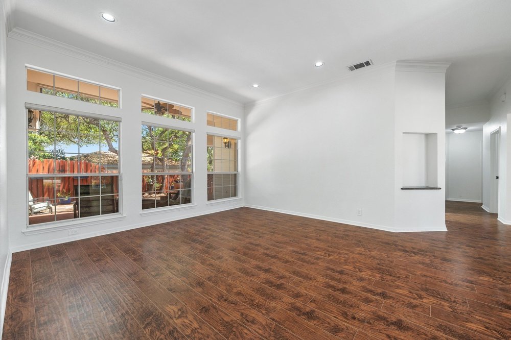 209 El Rio Drive Lakeway, TX 78734 - Photo 9 of 40 a view of an empty room with wooden floor and a window