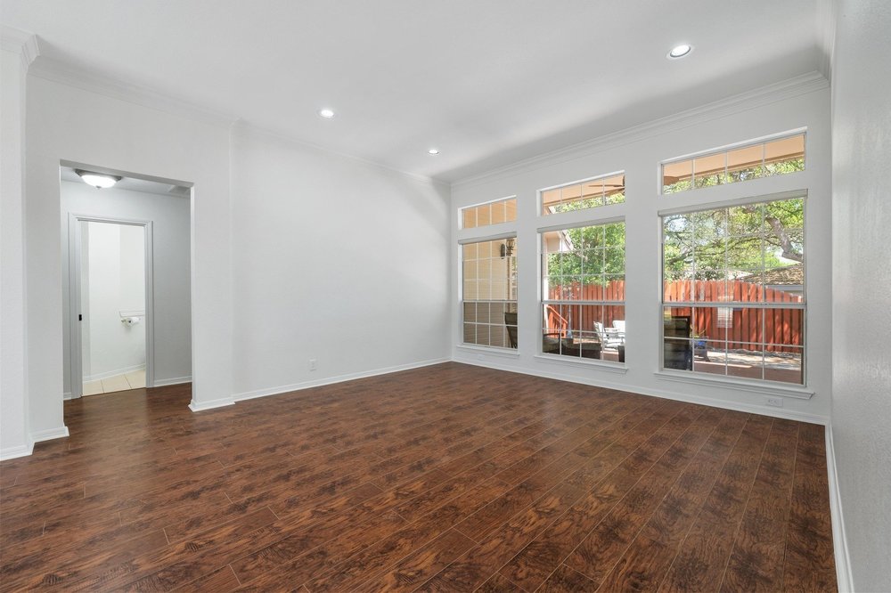 209 El Rio Drive Lakeway, TX 78734 - Photo 10 of 40 a view of an empty room with wooden floor and a window