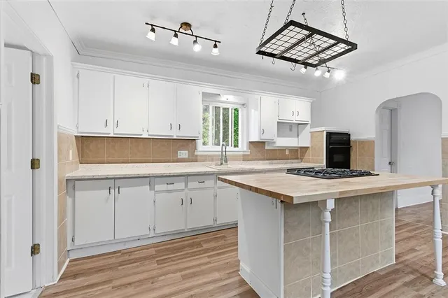 a kitchen with a stove and white cabinets