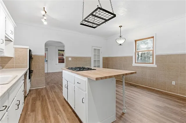 a kitchen with a stove and a wooden floor
