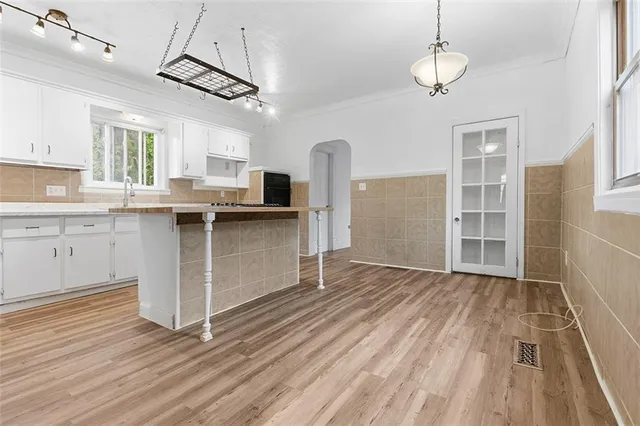 a kitchen with stainless steel appliances granite countertop a sink window and wooden floor