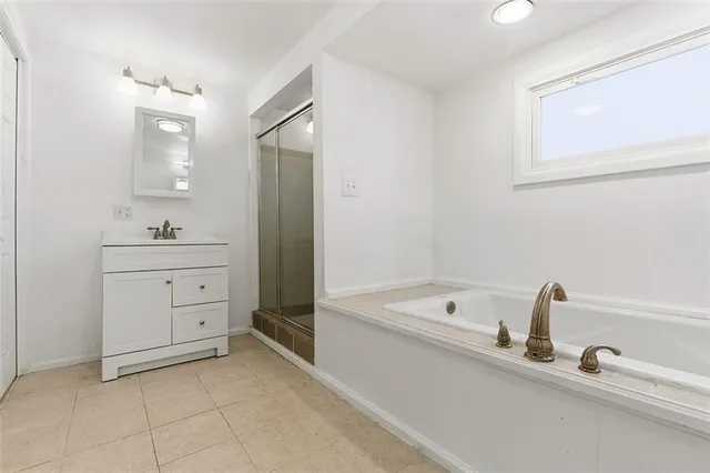 a bathroom with a tub sink and mirror