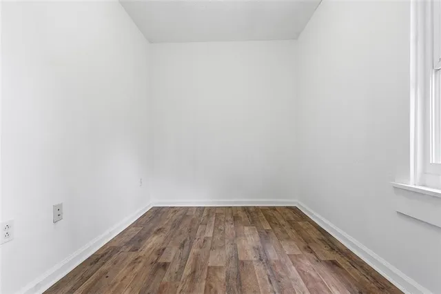 a view of a room that has wooden floor and white walls