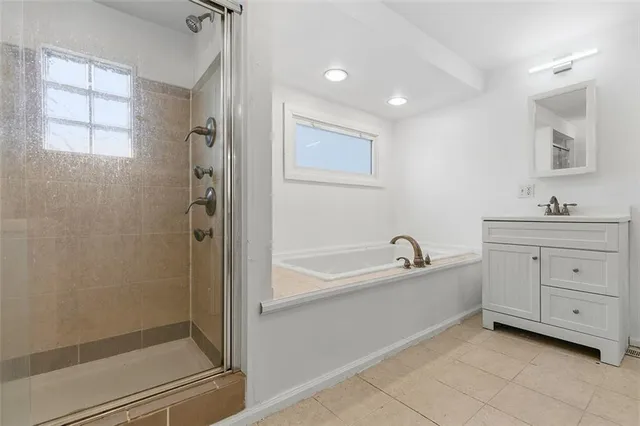 a bathroom with a bathtub a sink a vanity and a shower