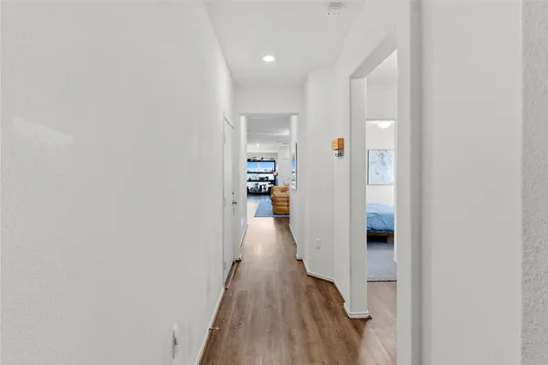 a view of a hallway with wooden floor and staircase