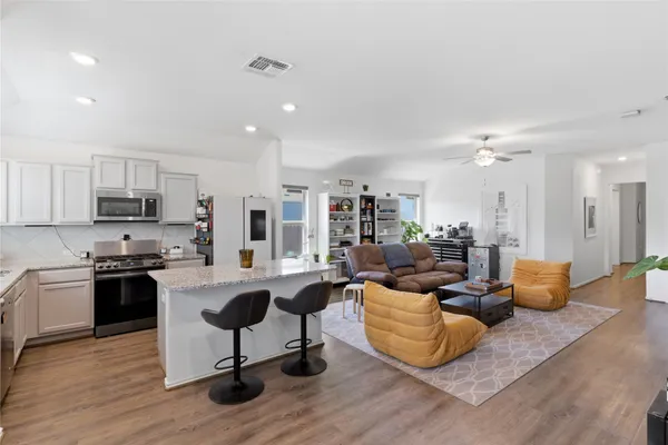 a view of a patio with couches and a table and chairs with wooden floor