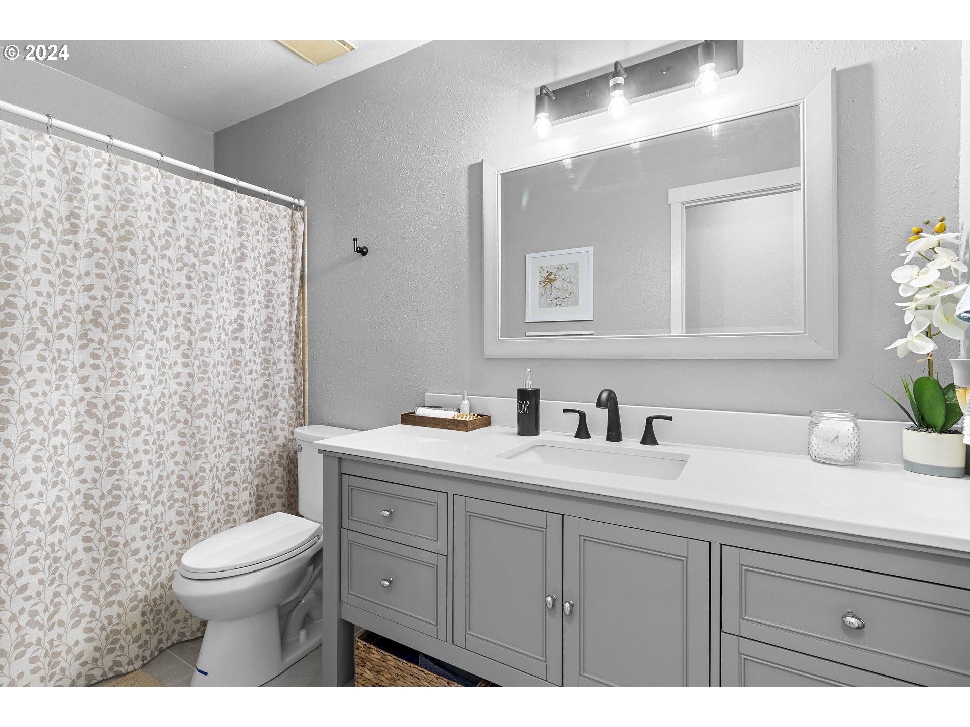 3121 Southwest Orchard Place Gresham, OR 97080 - Photo 29 of 48 a bathroom with a granite countertop toilet a sink a mirror and a shower
