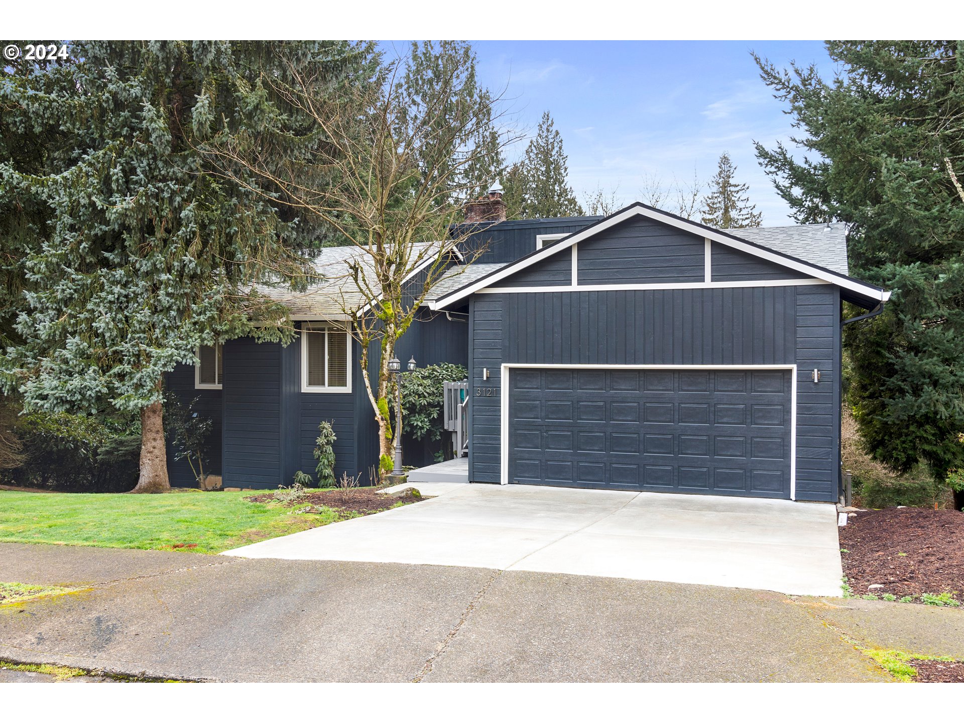 3121 Southwest Orchard Place Gresham, OR 97080 - Photo 3 of 48 a front view of a house with a yard and garage