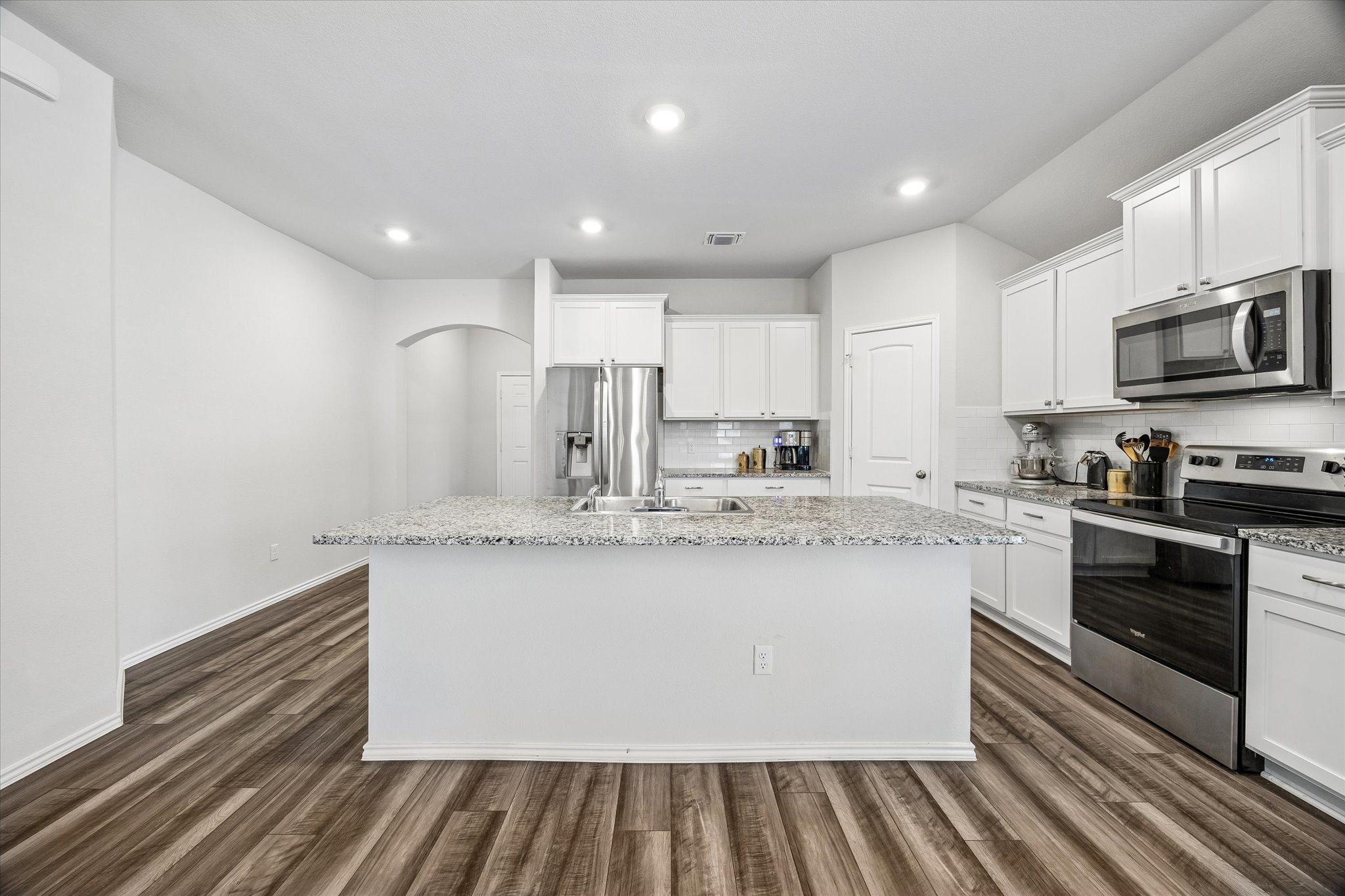 168 Onna Street Taylor, TX 76574 - Photo 7 of 30 a kitchen with kitchen island a sink stainless steel appliances and cabinets