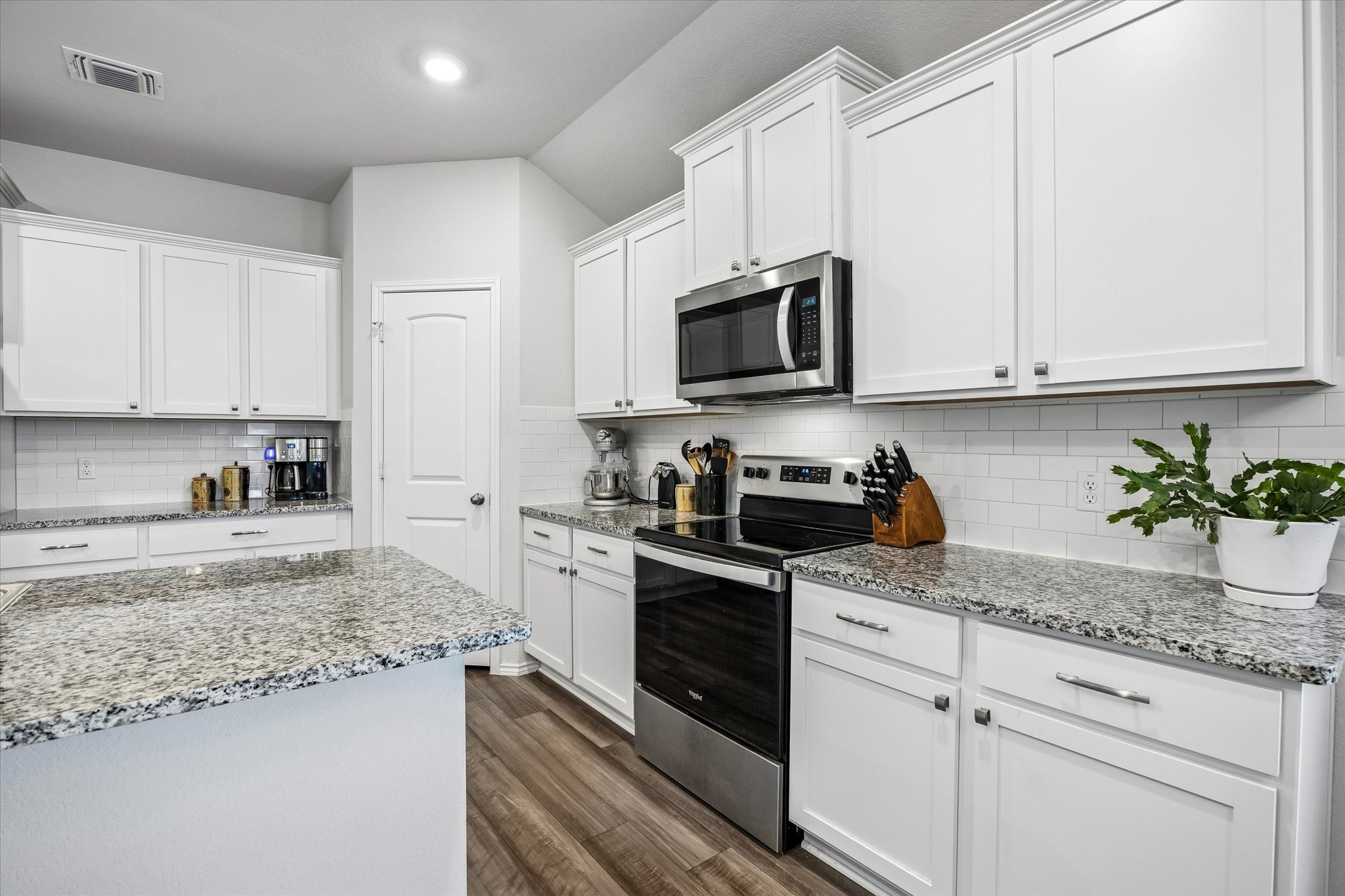 168 Onna Street Taylor, TX 76574 - Photo 9 of 30 a kitchen with granite countertop white cabinets and white appliances