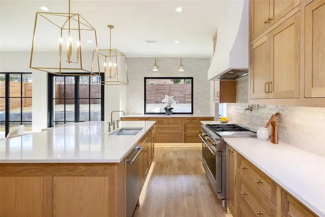 a large kitchen with stainless steel appliances a lot of counter space and a window
