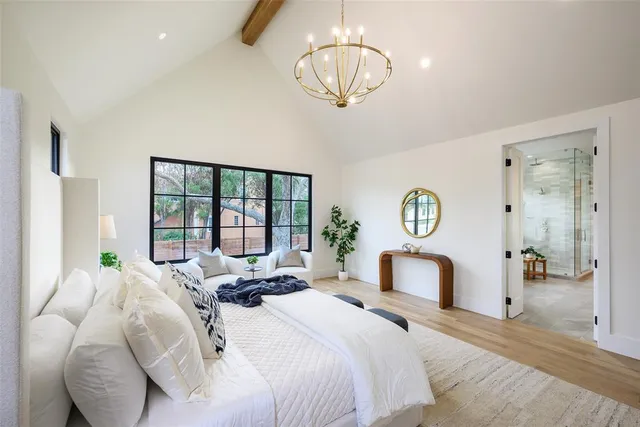 a bedroom with a bed mirror and window