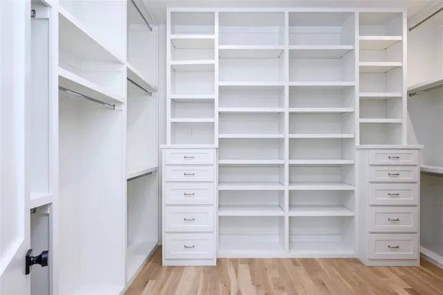 a view of walk in closet with empty racks