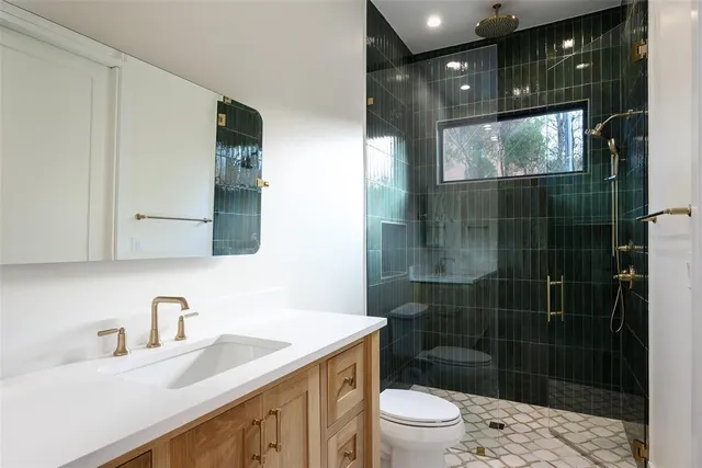 a bathroom with a sink vanity granite toilet and shower