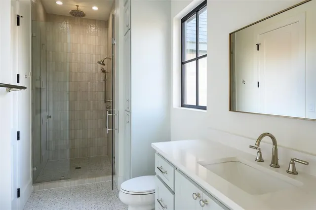 a bathroom with a sink a toilet and shower