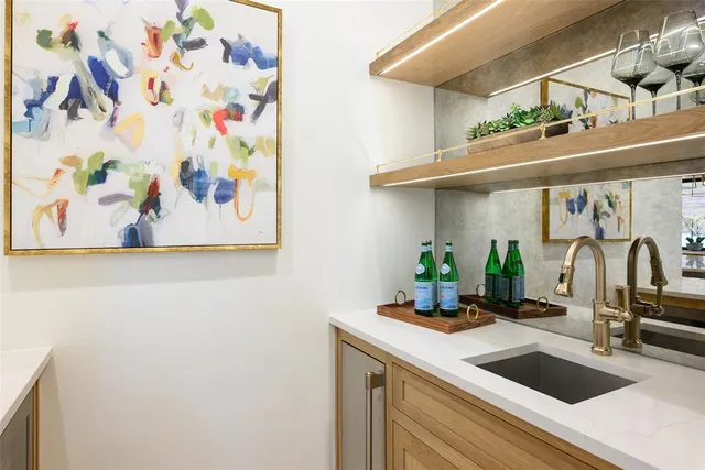 a kitchen with a sink and a painting on the wall