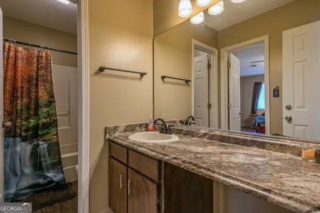 a bathroom with a granite countertop sink and a mirror