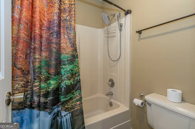 a bathroom with a shower curtain and a toilet