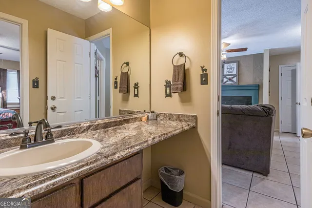 a bathroom with a granite countertop sink and a mirror