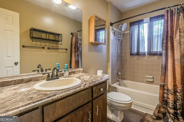 a bathroom with a granite countertop sink toilet and shower
