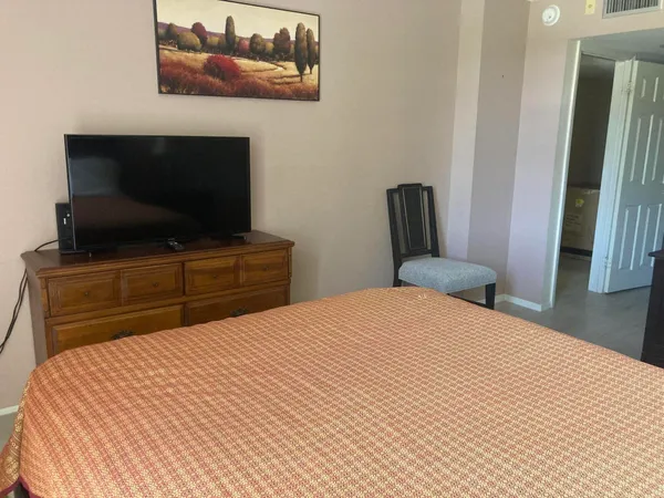 a bedroom with a bed and a flat screen tv