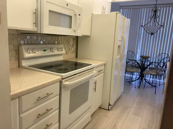 a kitchen with cabinets and wooden floor