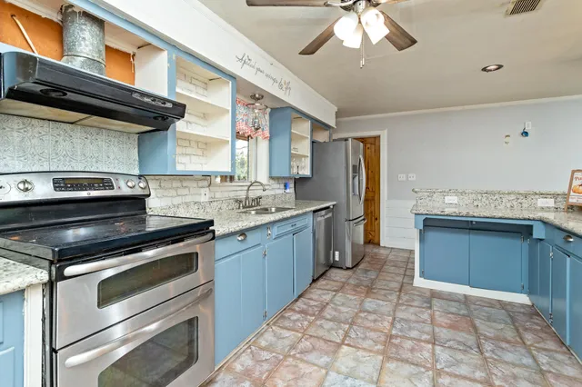 a large kitchen with stainless steel appliances granite countertop a stove and a sink