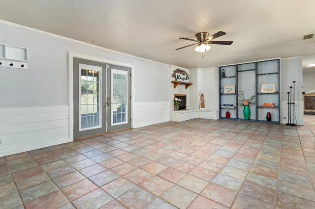 a view of an empty room with window and a ceiling fan