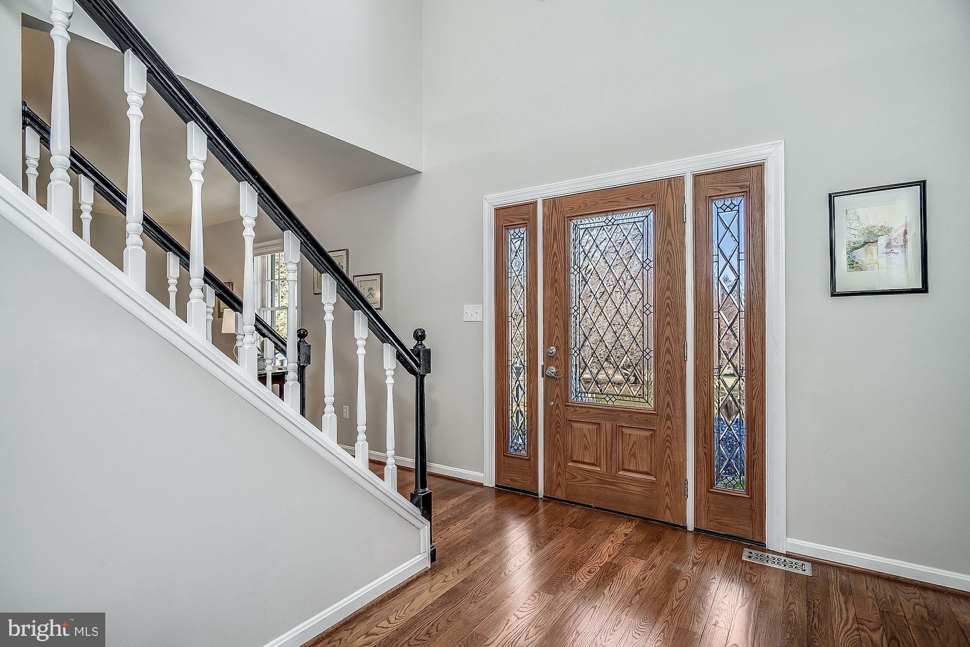 Two Story Foyer Sided by Living Room & Study