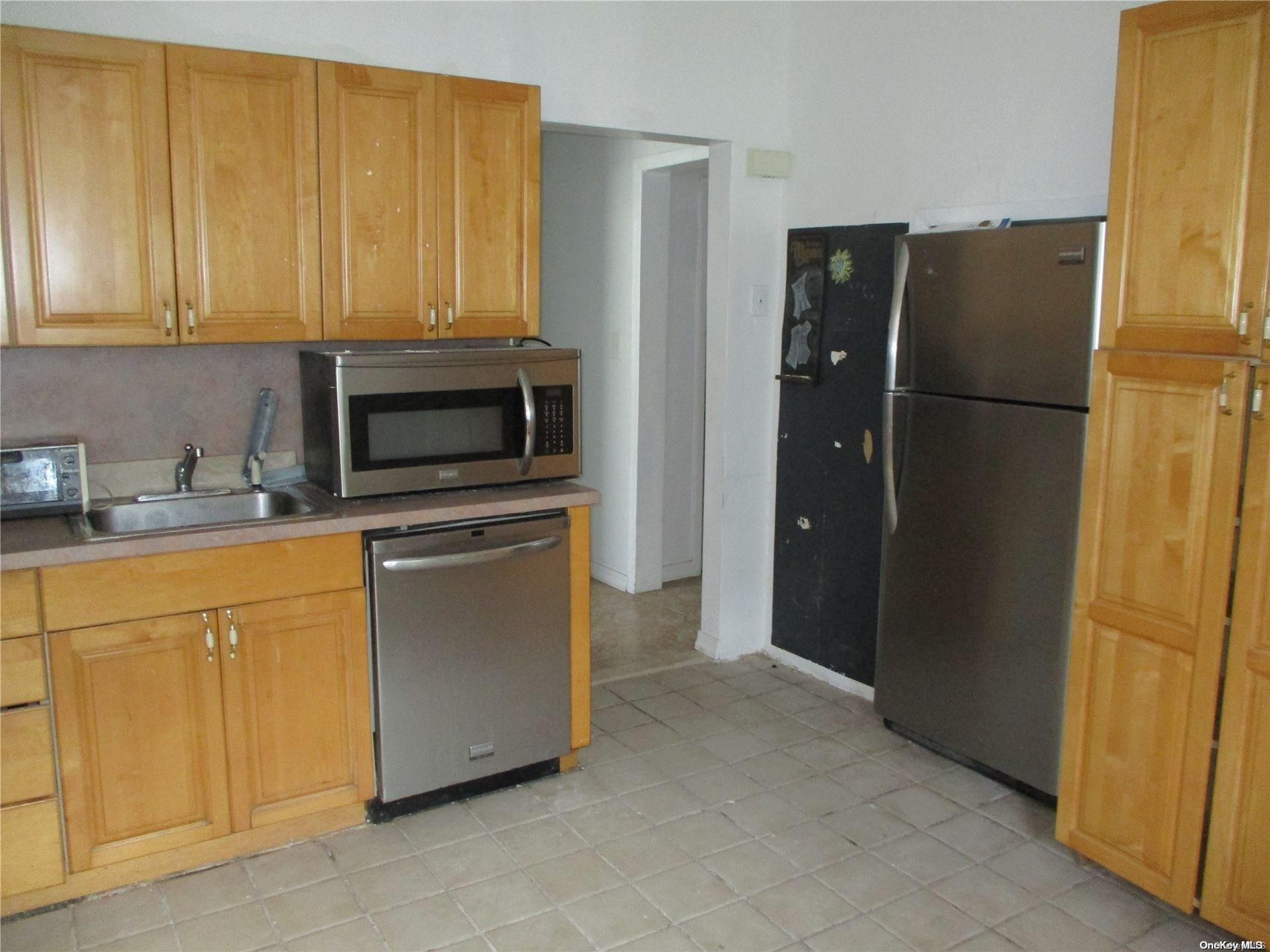 135 Beach 124th Street Queens, NY 11694 - Photo 3 of 25 a kitchen with stainless steel appliances granite countertop a refrigerator a stove and a sink