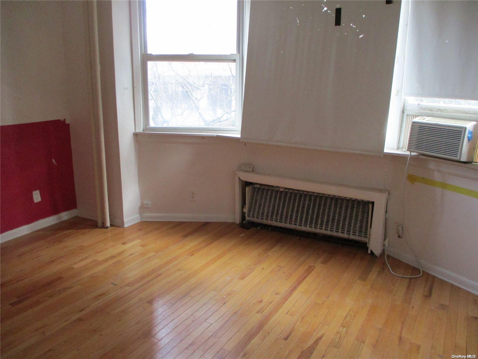 135 Beach 124th Street Queens, NY 11694 - Photo 5 of 25 an empty room with wooden floor and windows
