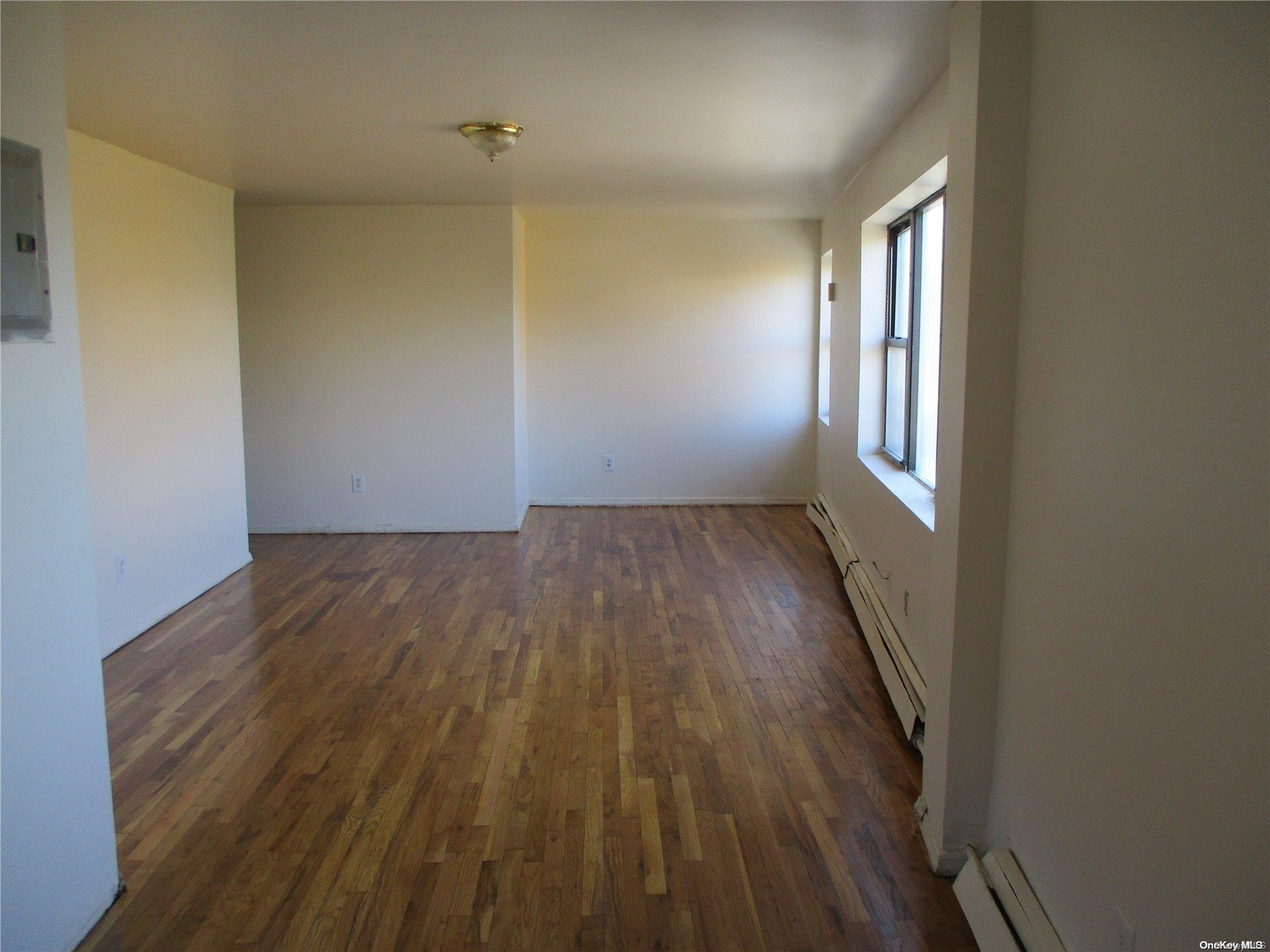 135 Beach 124th Street Queens, NY 11694 - Photo 6 of 25 wooden floor in an empty room with a window