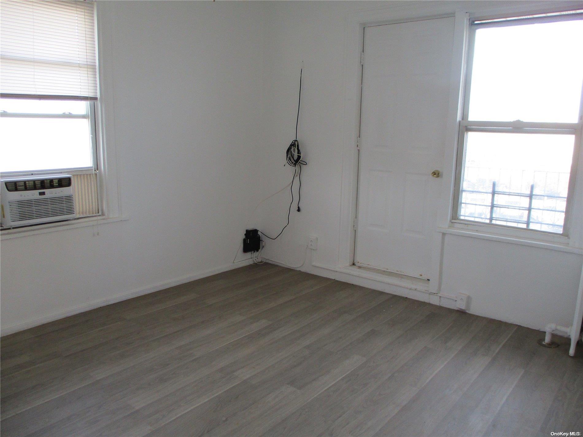 135 Beach 124th Street Queens, NY 11694 - Photo 10 of 25 an empty room with wooden floor and windows