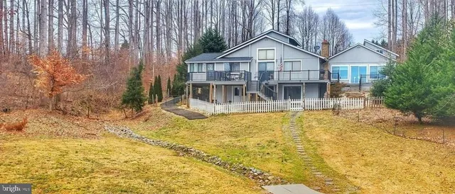 a view of house with large trees in front of it