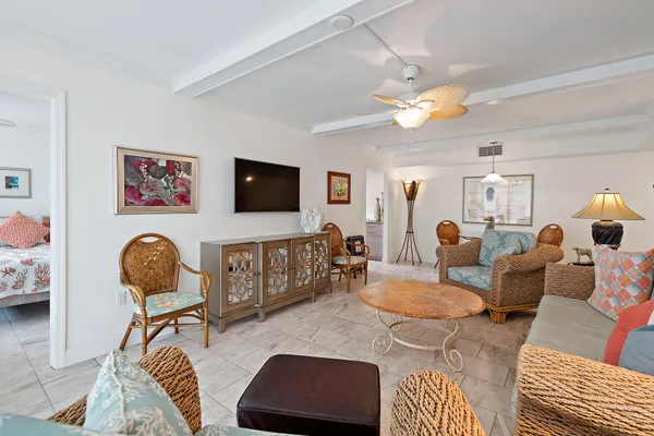 a living room with furniture a flat screen tv and a floor to ceiling window