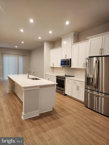 a kitchen with a sink stainless steel appliances and white cabinets