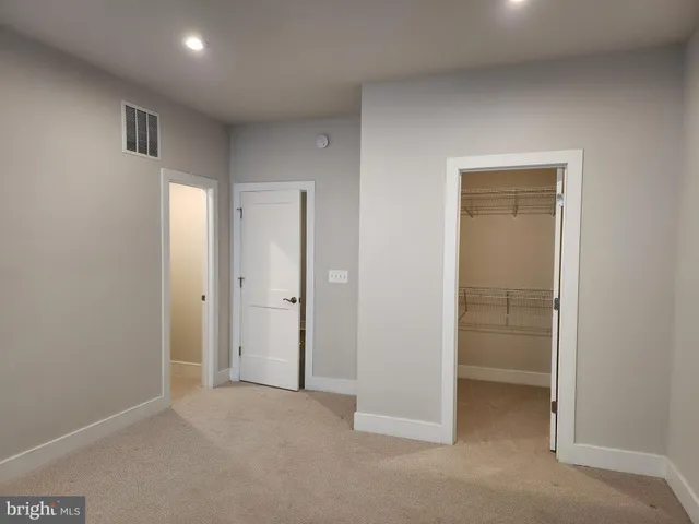 an empty room with closet and a bathroom