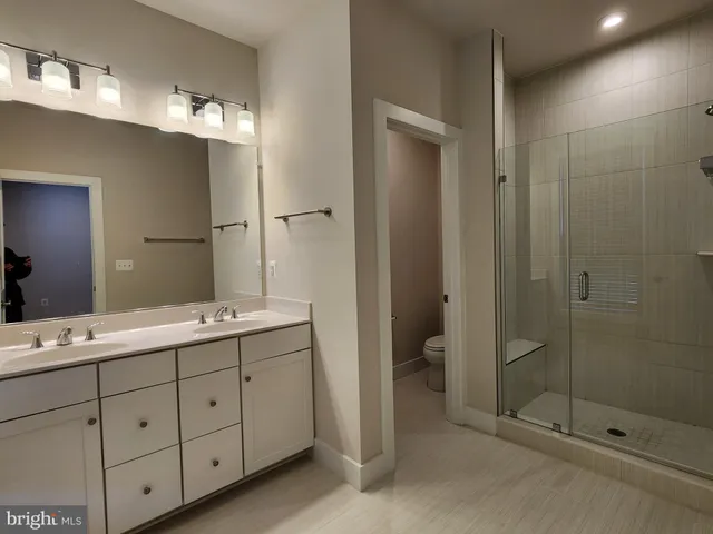 a bathroom with a double vanity sink mirror and shower