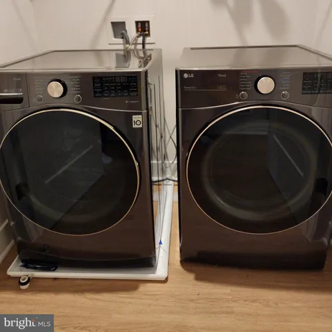 a washer and dryer sitting next to a wooden floor