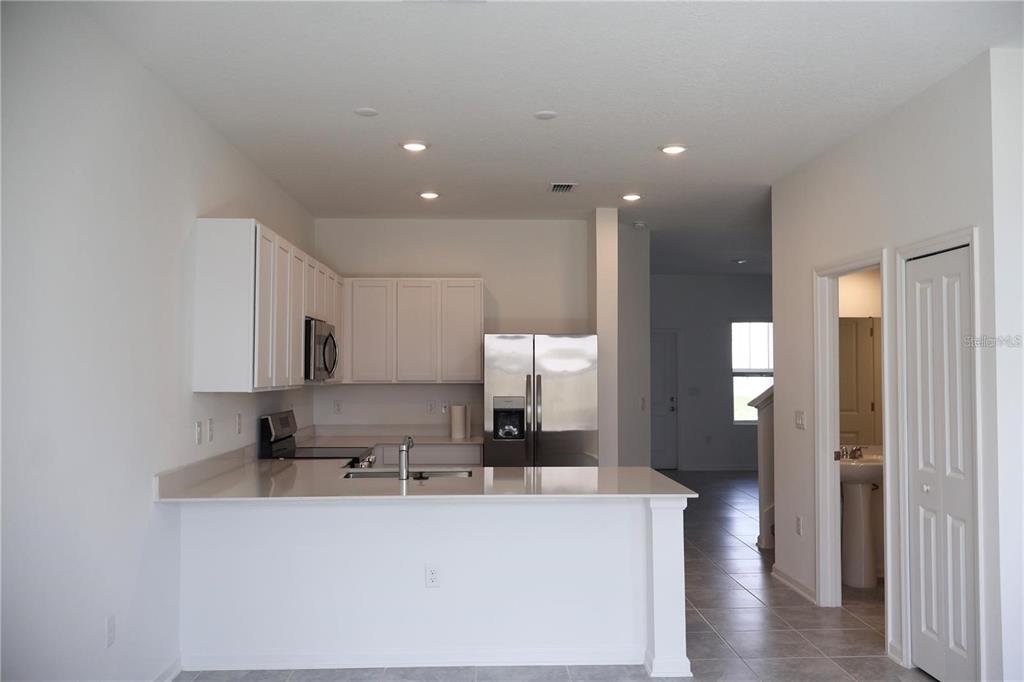 2452 Skyline Loop Kissimmee, FL 34758 - Photo 3 of 12 a view of a kitchen with center island and stainless steel appliances