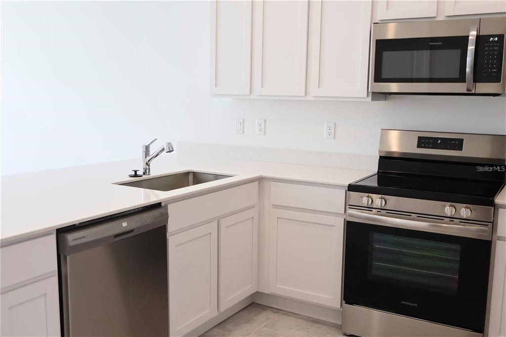2452 Skyline Loop Kissimmee, FL 34758 - Photo 4 of 12 a kitchen with a stove and a microwave