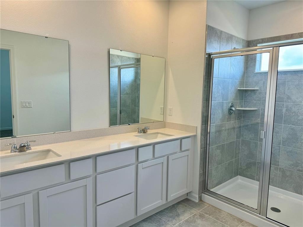 2452 Skyline Loop Kissimmee, FL 34758 - Photo 9 of 12 a bathroom with a shower sink and mirror