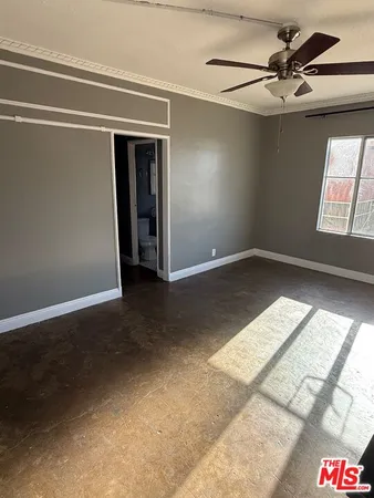 en empty room with windows and ceiling fan