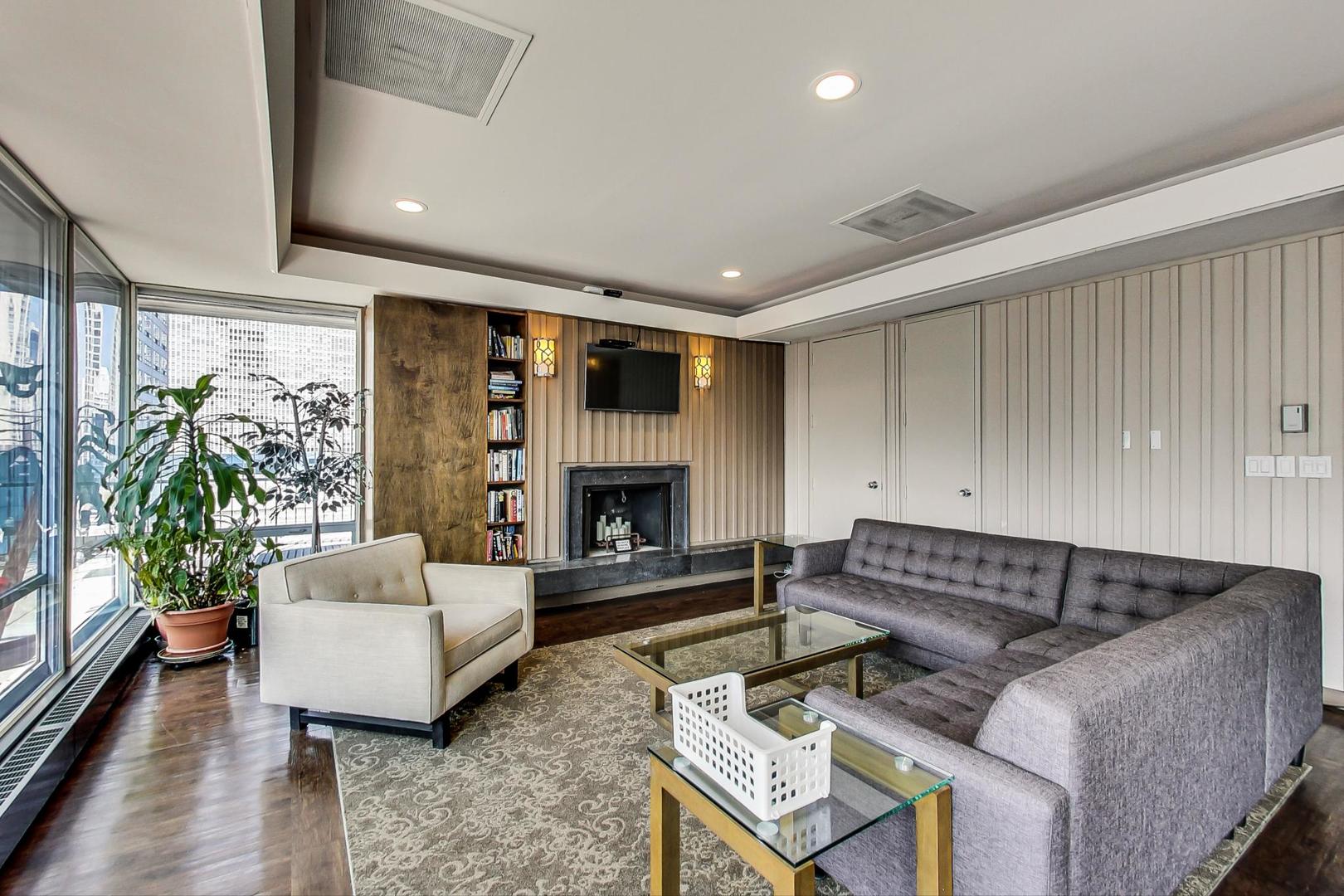 201 East Chestnut Street, Unit 19F Chicago, IL 60611 - Photo 25 of 36 a living room with furniture fireplace and a large window