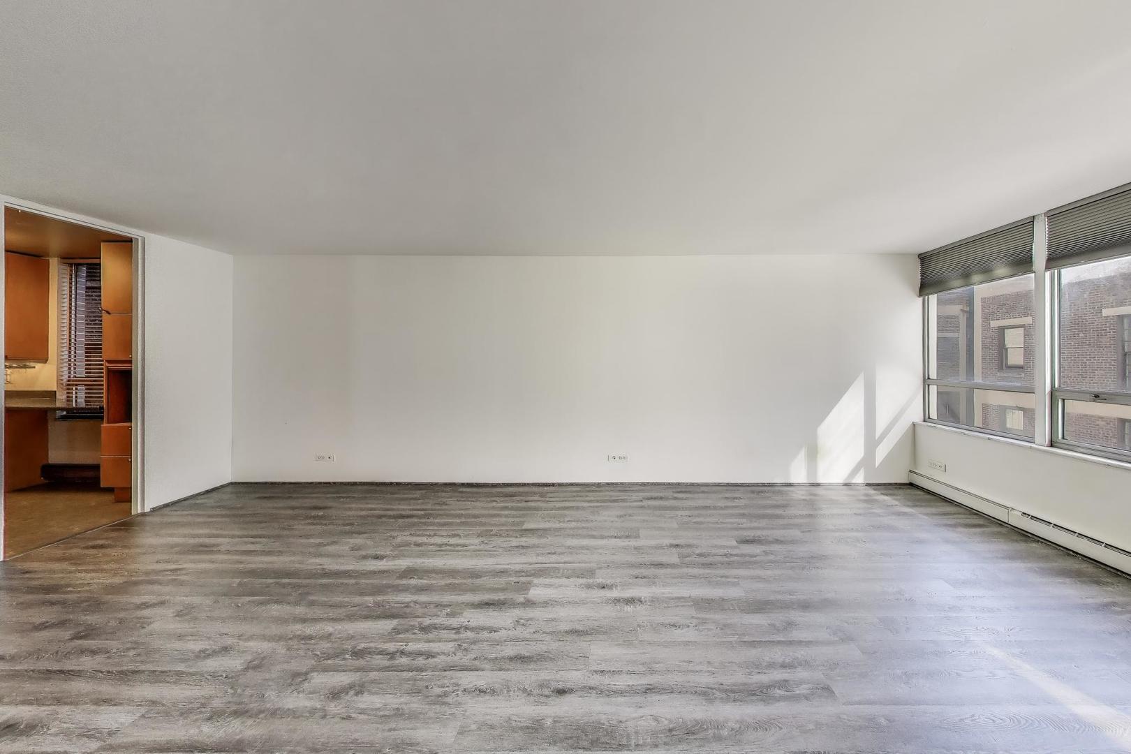 201 East Chestnut Street, Unit 19F Chicago, IL 60611 - Photo 8 of 36 a view of an empty room with window and wooden floor